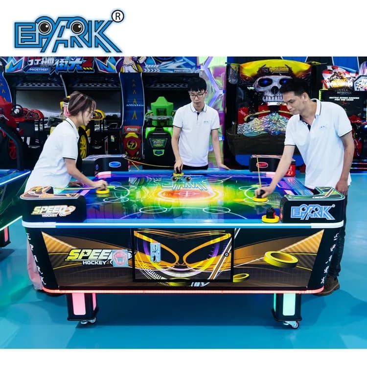 Four players using a square commercial air hockey table in an arcade