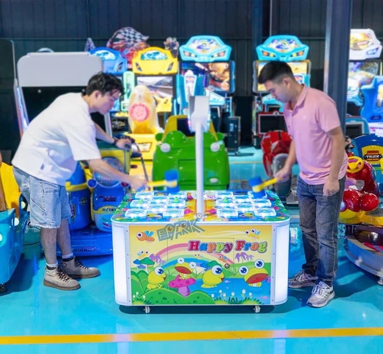 Dos jugadores utilizando lados opuestos de la máquina de martillo de rana en la sala de exposición.