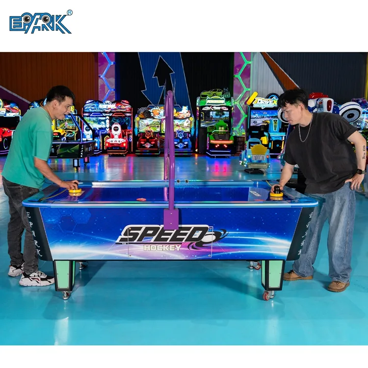 Two players using an arcade air hockey table with overhead scoring