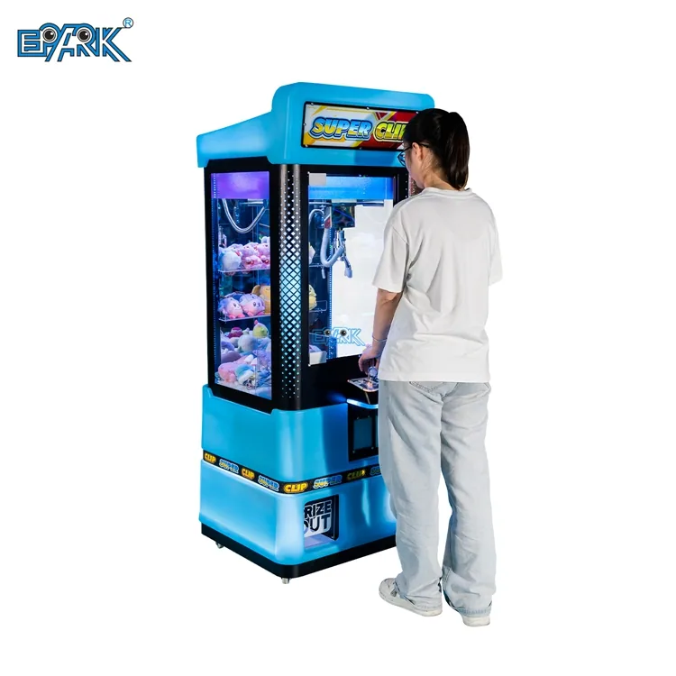 Player using a blue compact claw machine in an arcade