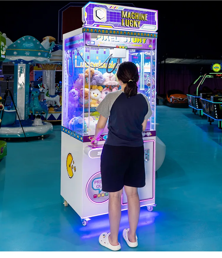Player using an illuminated toy claw machine in an arcade showroom