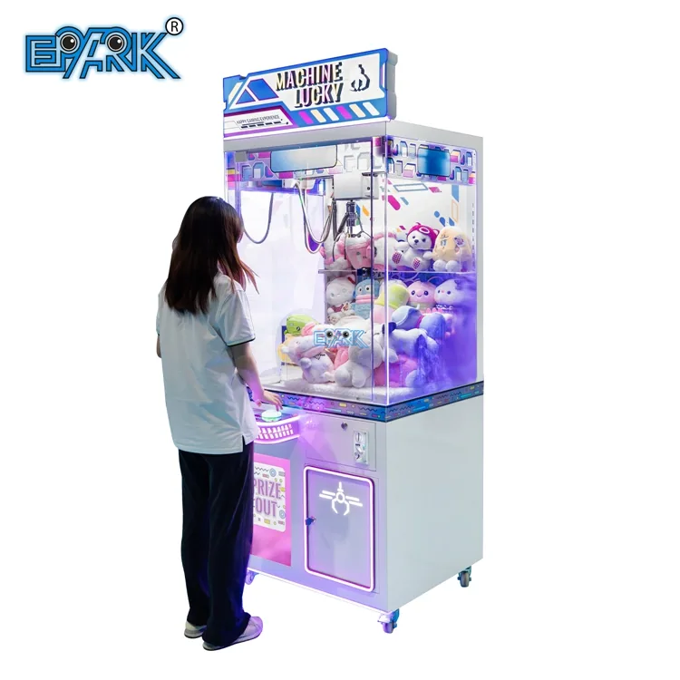 Player using a transparent prize claw machine in an arcade